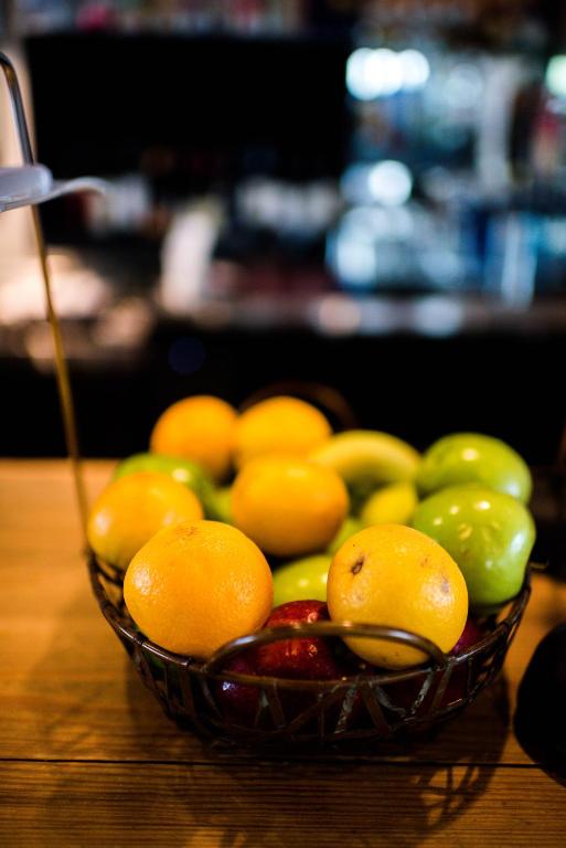 a bowl of fruit on a wooden table at Cotton Court Hotel, by Valencia Hotel Collection in Lubbock