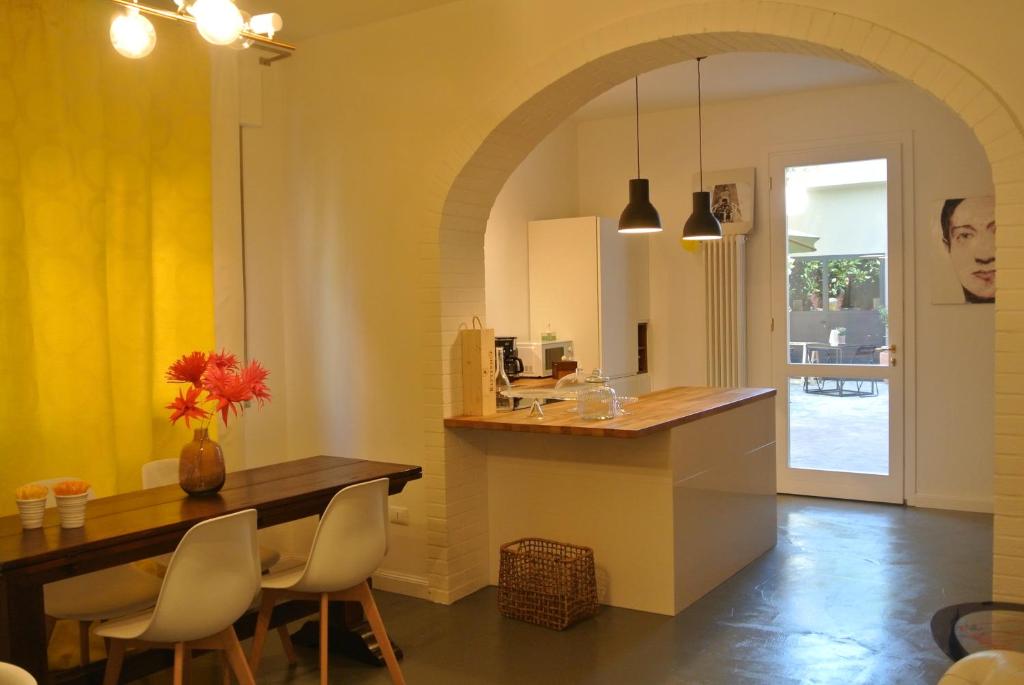 a kitchen with an archway and a table and chairs at QuarantaVasi in Ravenna