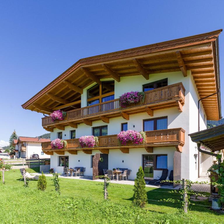 a building with balconies and flowers on it at Appartement Holaus in Westendorf