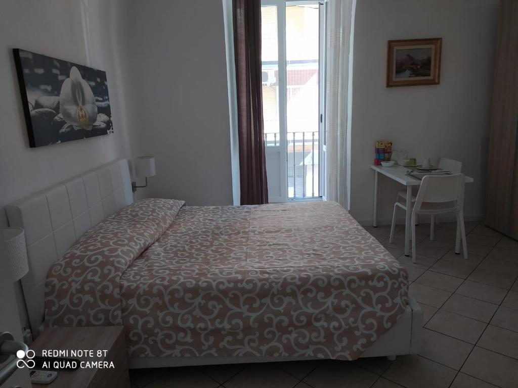 1 dormitorio con cama, mesa y ventana en B&B Dolce Incanto, en Bari