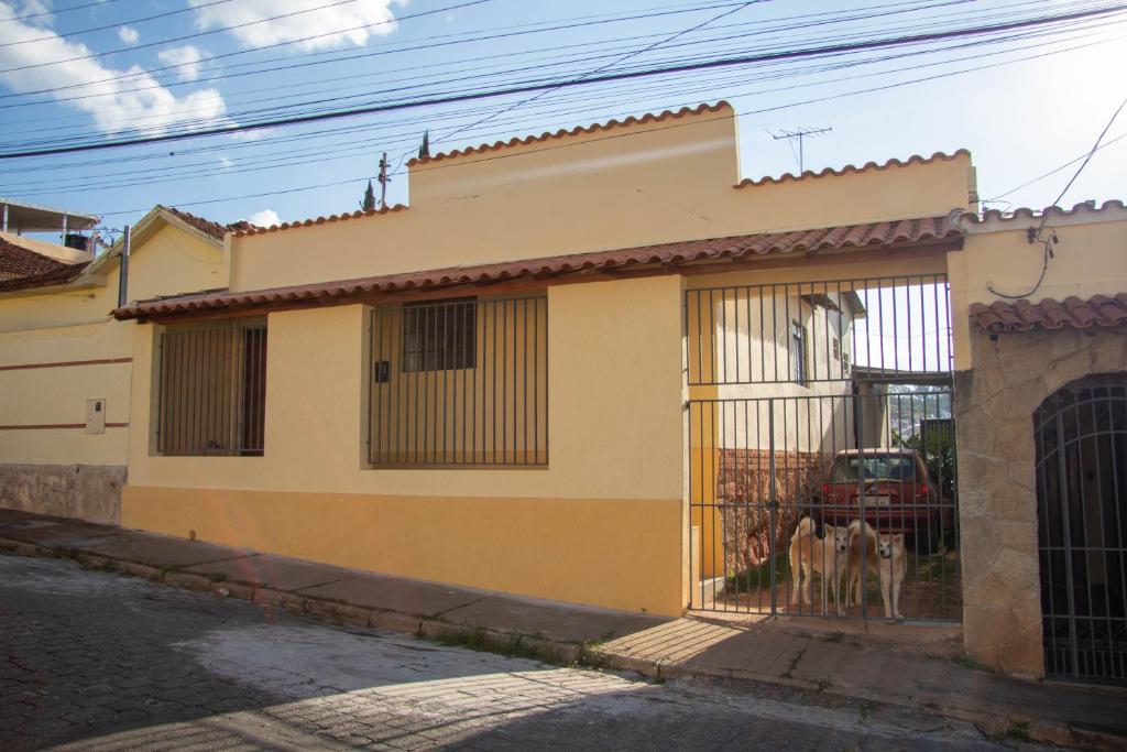 a dog standing in the doorway of a house at Casa do Juá in Lavras
