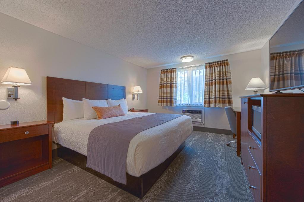 ein Hotelzimmer mit einem Bett und einem TV in der Unterkunft Silver Inn in Kellogg
