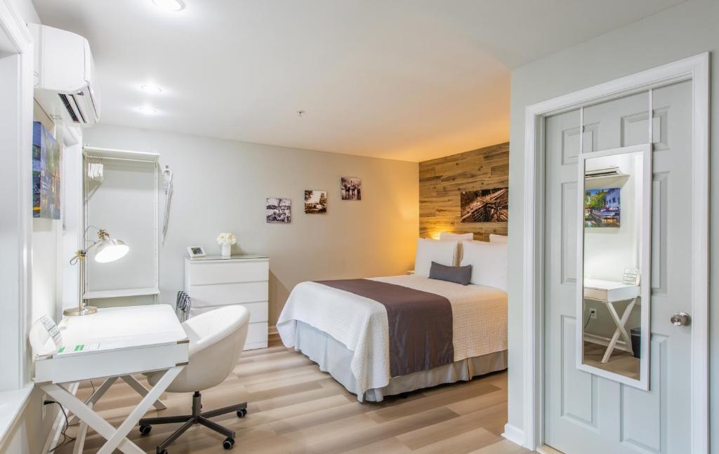 um quarto de hotel com uma cama, uma secretária e um espelho em The Georgetown House Inn em Washington
