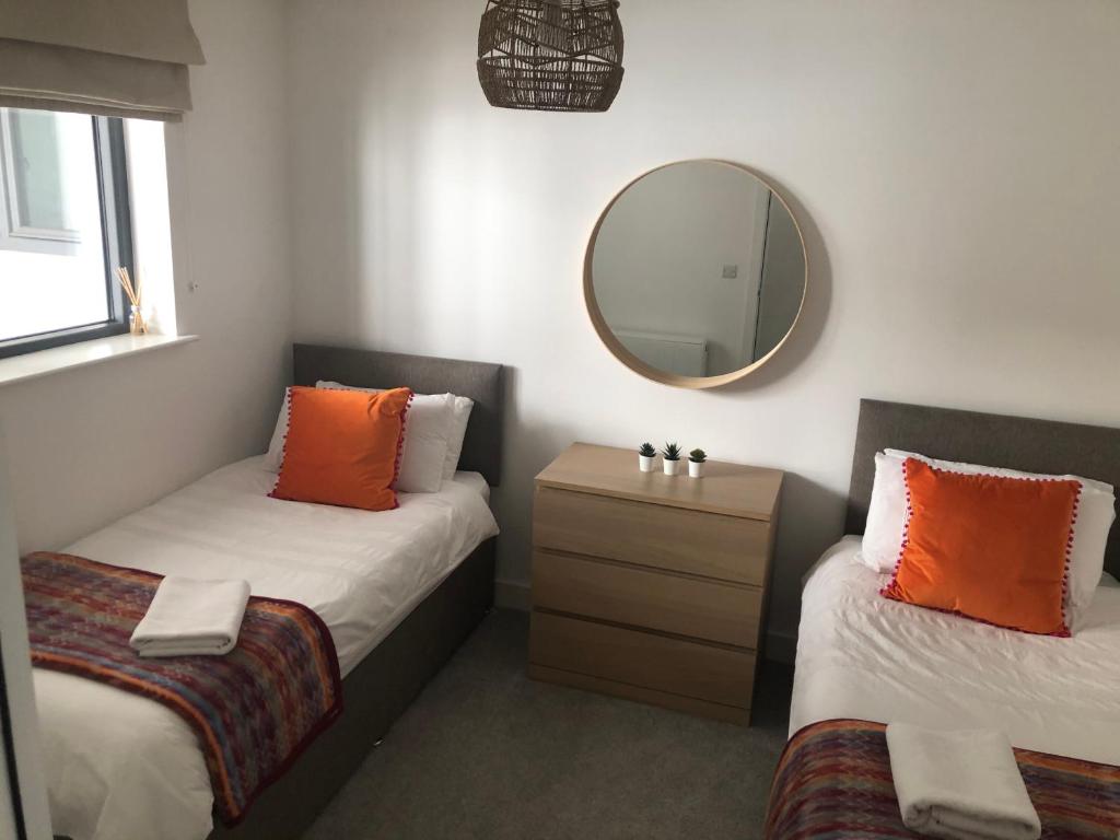 a small room with two beds and a mirror at Luxury apartment in the heart of Portrush Main St in Portrush
