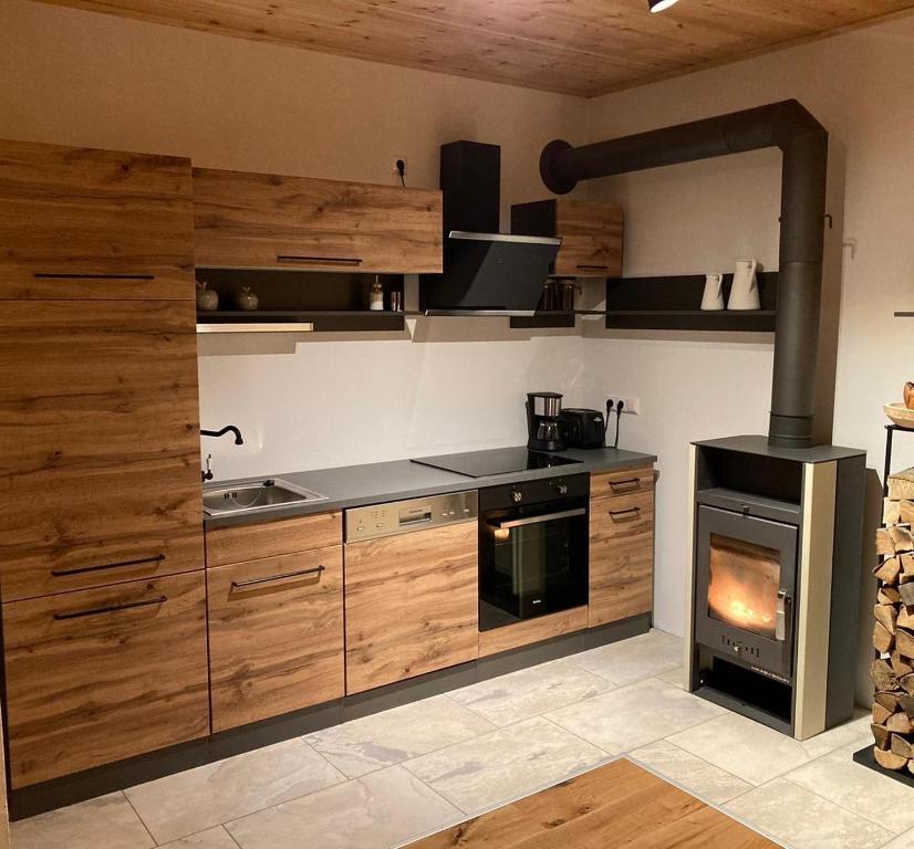 a kitchen with wooden cabinets and a stove at Zirben Appartement zwischen Berg und See in Steindorf am Ossiacher See