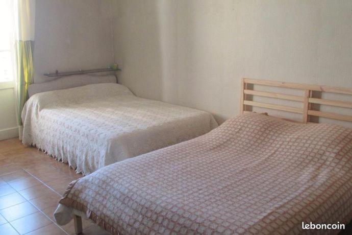 Appartement sur Sommières jusqu'à 6 personnes في سوميريس: غرفة نوم بسريرين ونافذة