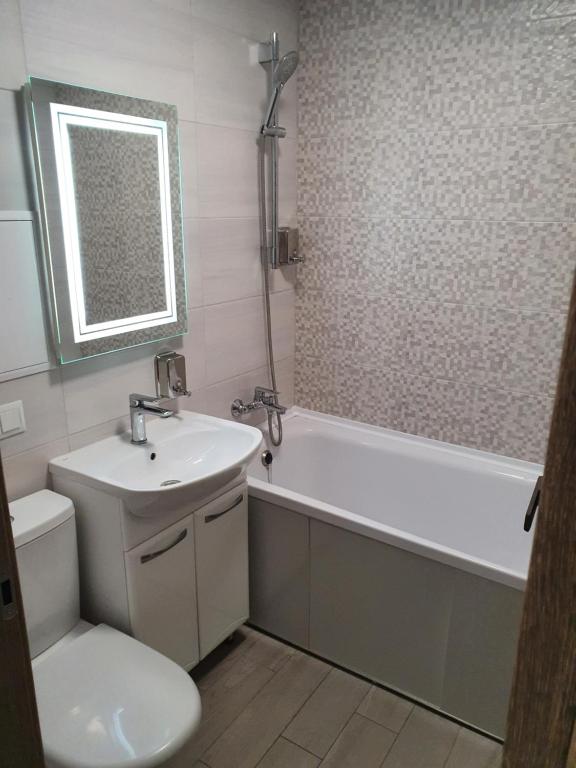 a bathroom with a sink and a tub and a toilet at Apartment on Tarkovskogo 2 in Kropyvnytskyi