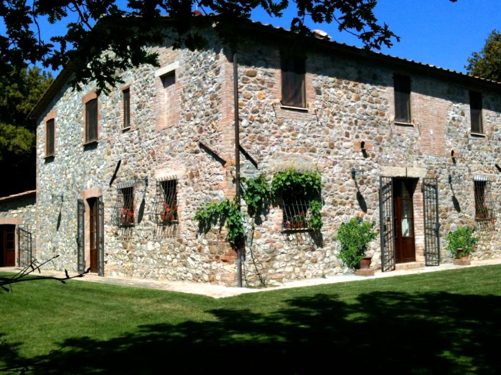 ein großes Steingebäude mit Fenstern und einem Hof in der Unterkunft Tenuta Vitalonga in Ficulle