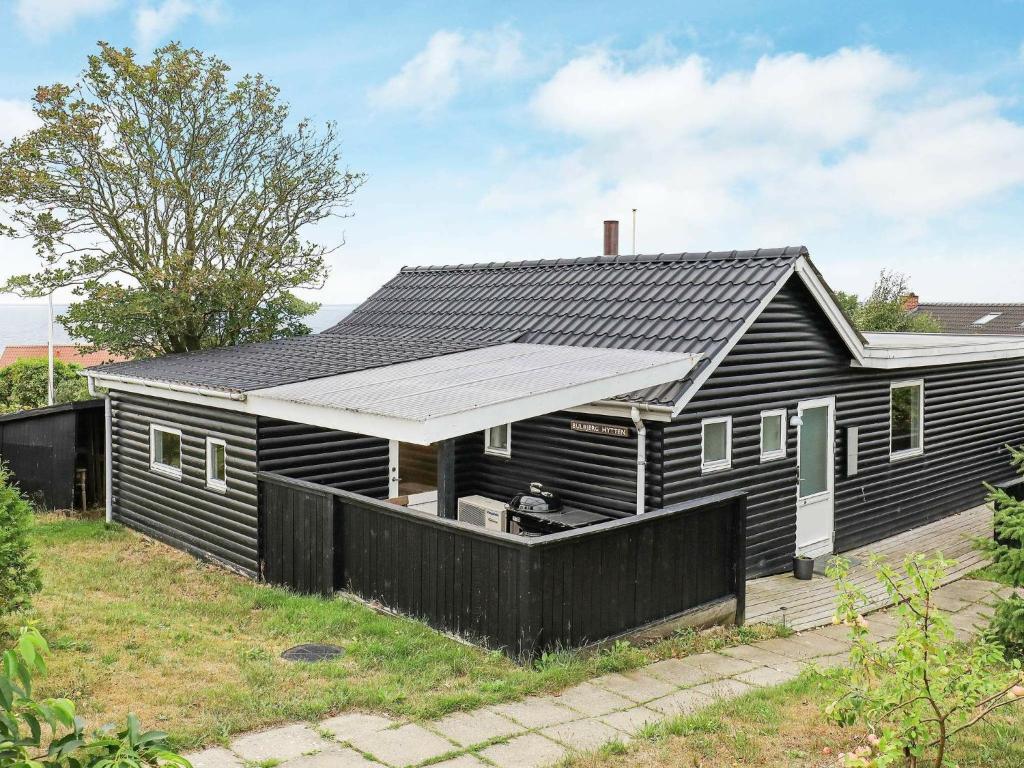 a black house with a solar panel on the roof at 6 person holiday home in Esbjerg V in Esbjerg