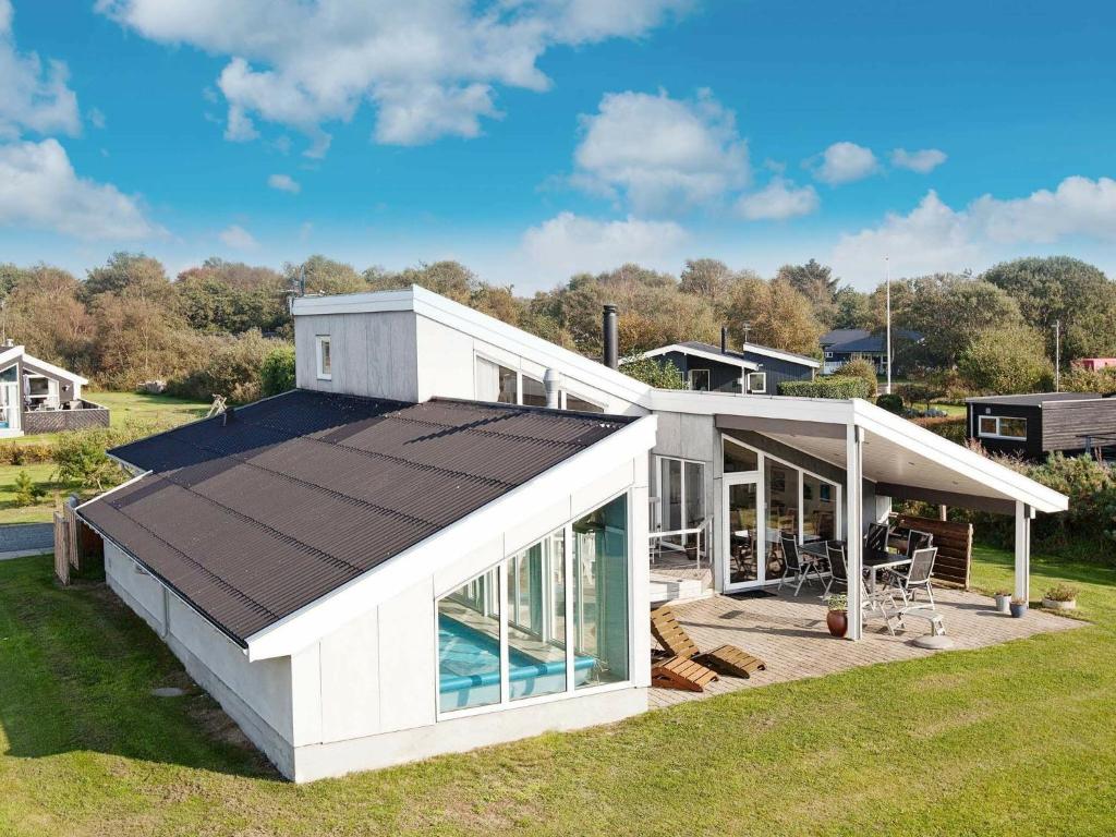 a white house with a swimming pool and a roof at 10 person holiday home in Ebeltoft in Ebeltoft
