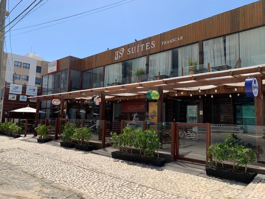 a building with potted plants in front of it at Transcar Suítes in Aracaju