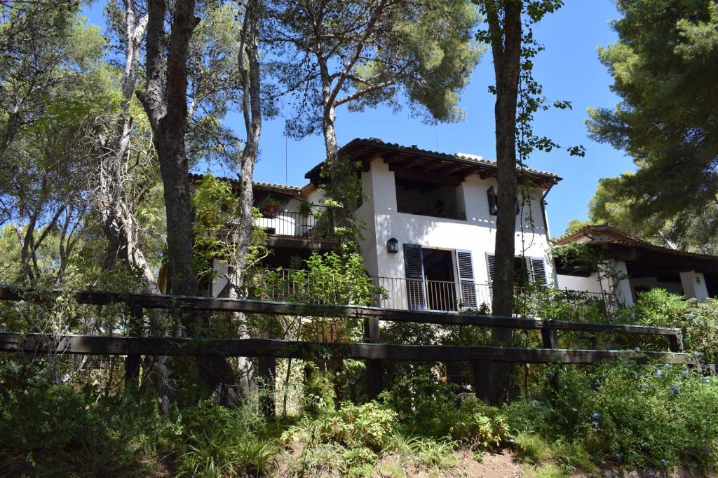 a house in the woods with a fence at L'Àncora de Barà in Roda de Bará