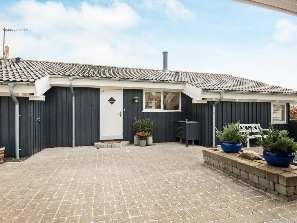 a house with a black fence and a patio at 6 person holiday home in Ebeltoft in Ebeltoft
