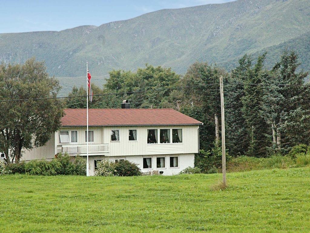 una gran casa blanca con techo rojo en un campo en Two-Bedroom Holiday home in Farstad 1, en Farstad