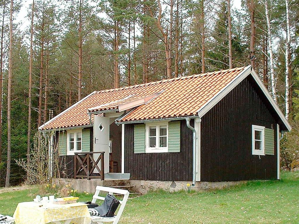 a small black house with a red roof at 4 person holiday home in HALLABRO-By Traum in Svarvaremåla