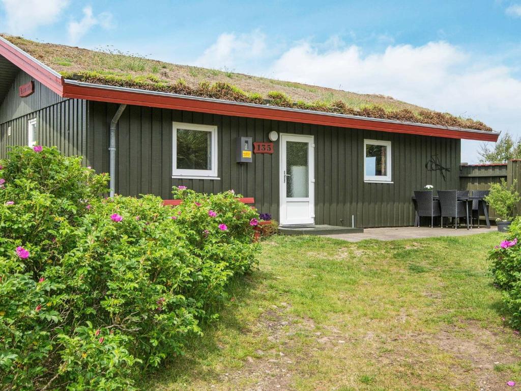 uma pequena casa verde com telhado de relva em 6 person holiday home in R m em Bolilmark