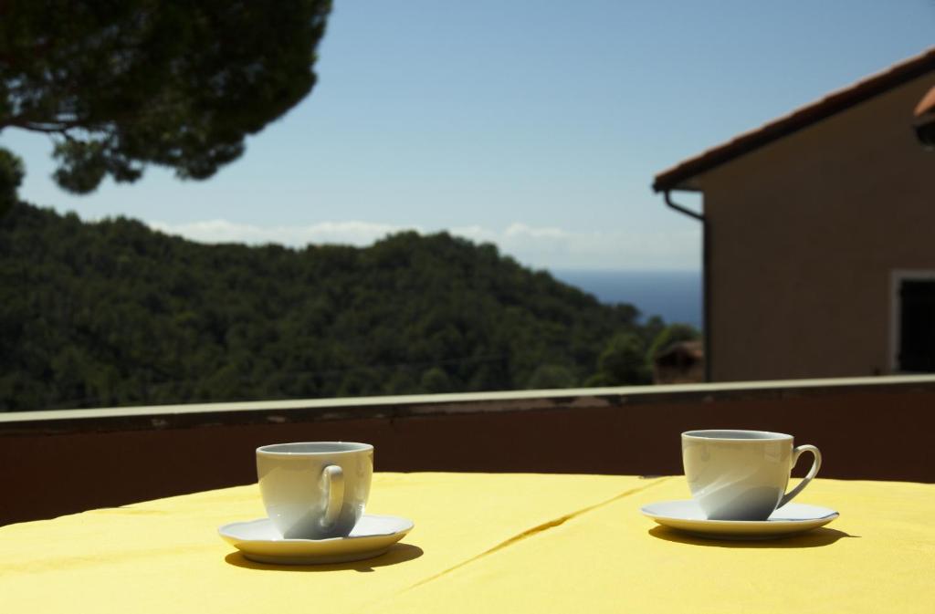 2 tazas de café sentadas en una mesa en un balcón en Nonna Maria, en Moneglia