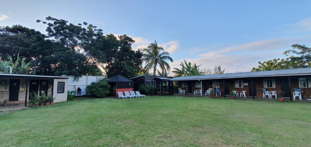 uma casa com um grande quintal em frente em Camping Hostal Tipanie Moana Aeropuerto Centro em Hanga Roa