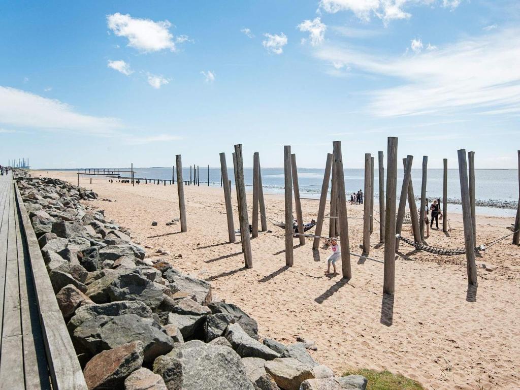 a beach with wooden posts in the sand at 4 person holiday home in Esbjerg V in Esbjerg