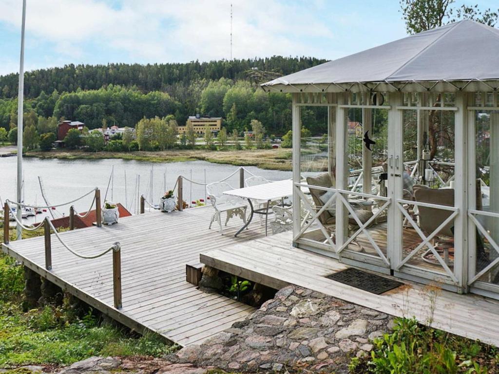 muelle de madera con cenador en un lago en 4 person holiday home in VALDEMARSVIK en Valdemarsvik