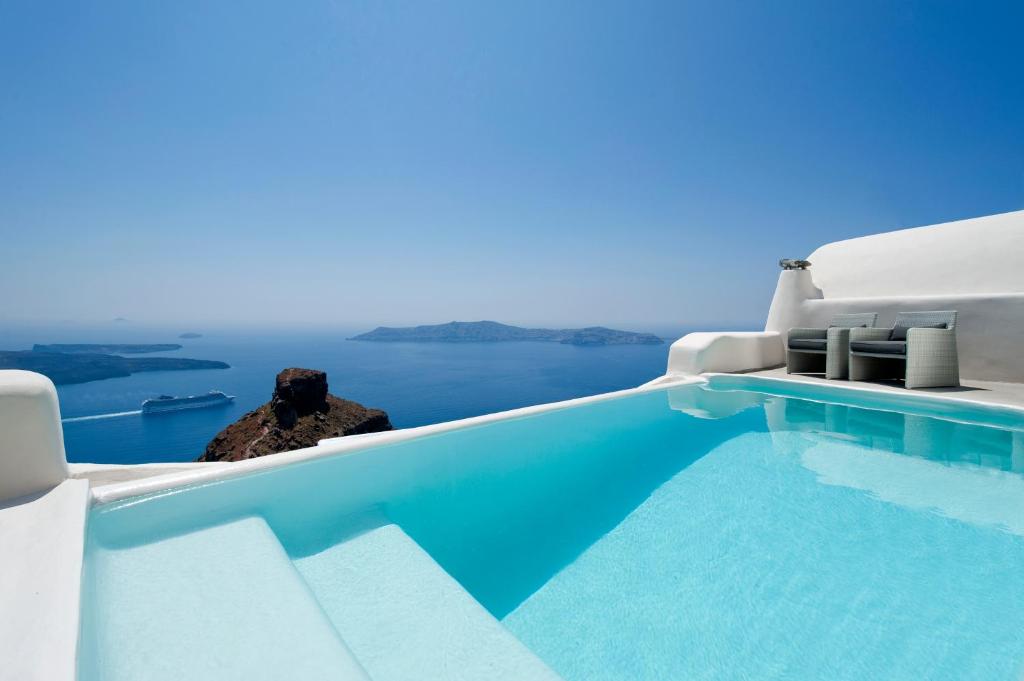 a swimming pool with a view of the ocean at Kapari Natural Resort in Imerovigli