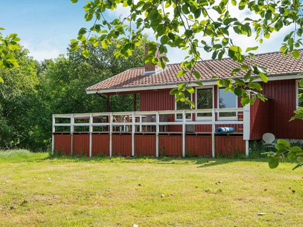 ein rotes Haus mit einem weißen Zaun im Hof in der Unterkunft 6 person holiday home in Glesborg in Glesborg