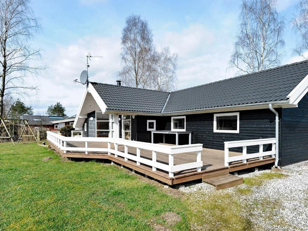 a blue house with a porch and a deck at 10 person holiday home in F rvang in Fårvang