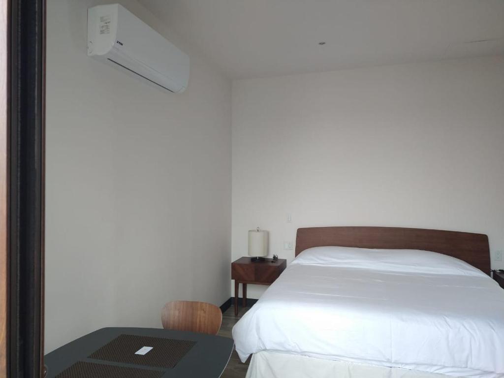 a bedroom with a bed and a table with a laptop at Suite Loft Deslumbrante Salida a México 102A in Querétaro