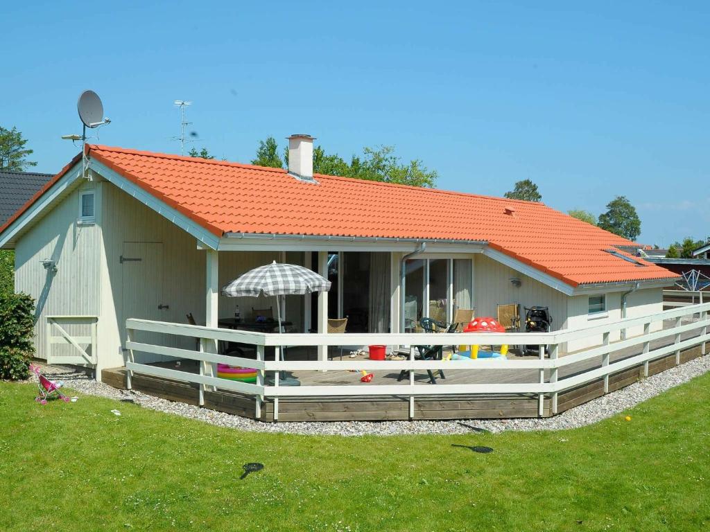una pequeña casa con techo naranja y patio en 10 person holiday home in B rkop en Egeskov