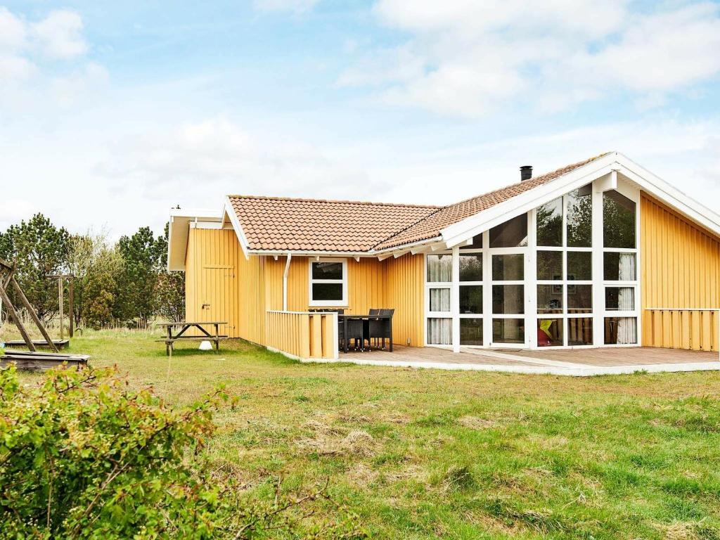 a yellow house with a large window at 8 person holiday home in Fan in Sønderho