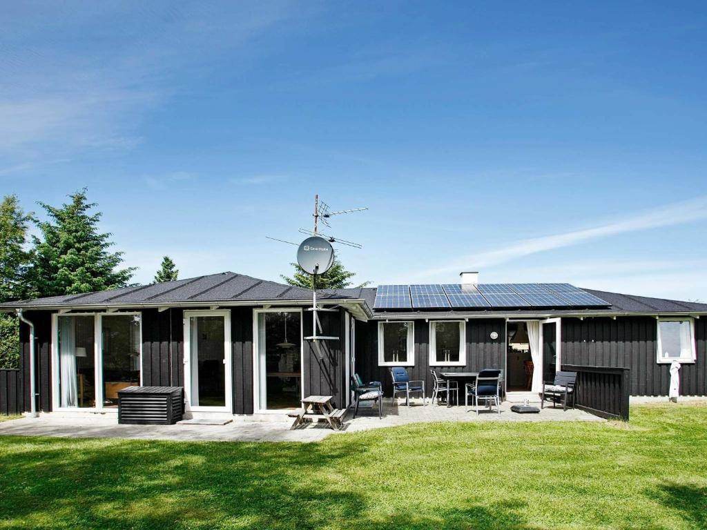 a house with a solar roof with a yard at Five-Bedroom Holiday home in Fjerritslev in Torup Strand