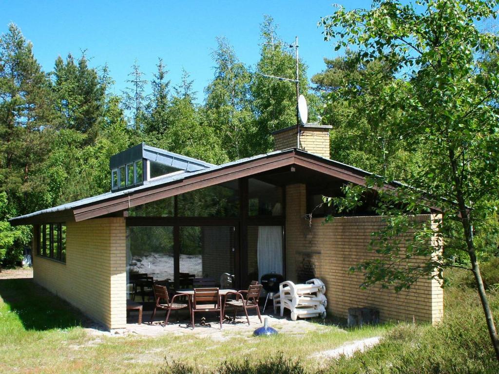 una pequeña casa de ladrillo con mesa y sillas en 6 person holiday home in Nex, en Spidsegård
