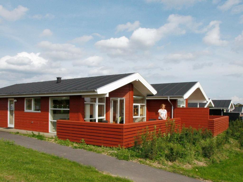 una casa roja con techo negro en 6 person holiday home in Tranek r, en Fæbæk