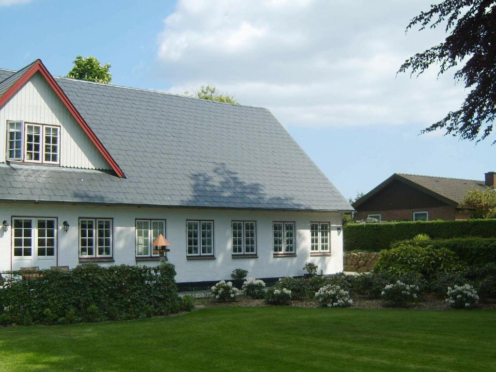 Biały dom z zielonym dziedzińcem w obiekcie 4 person holiday home in Aabenraa w mieście Kværs