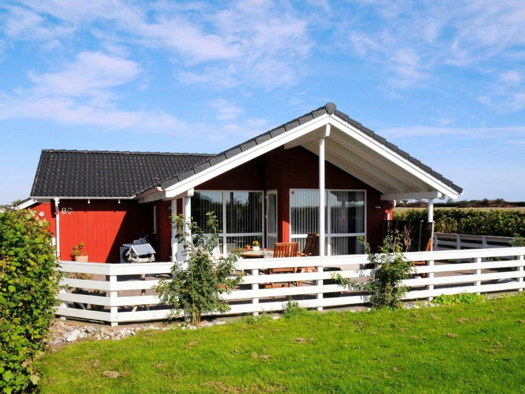 Årøsund的住宿－Holiday Home Raade III，前面有白色围栏的小房子