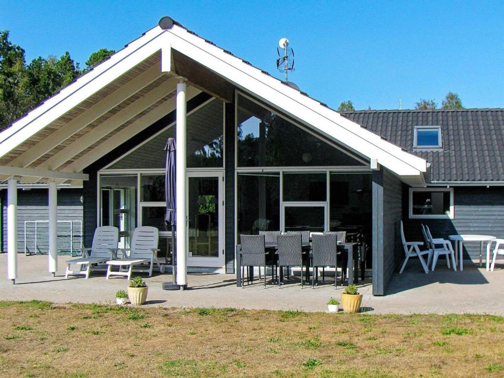 a pavilion with chairs and tables on a patio at 10 person holiday home in R dby in Rødby