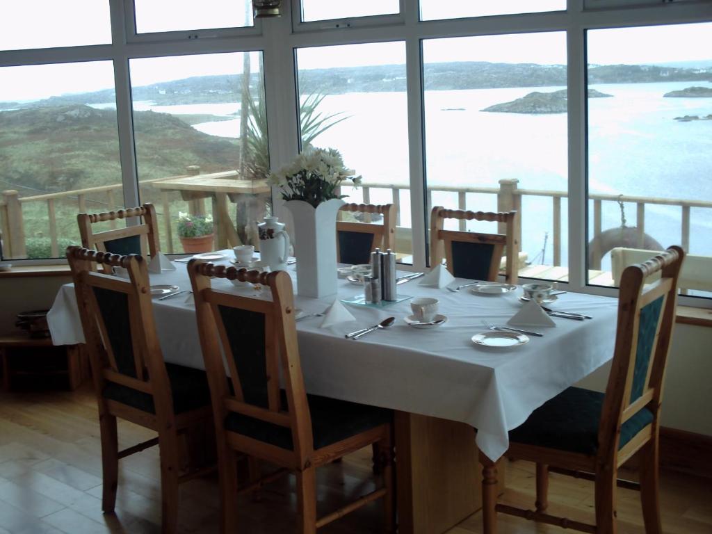 a table in a room with a view of the ocean at Teach Donncadh B&B in Kincasslagh