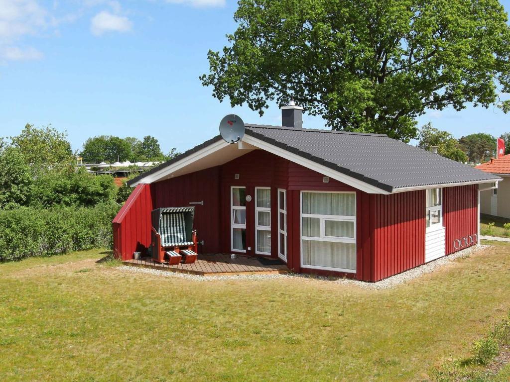 a red shed with a deck in a yard at 6 person holiday home in GROEMITZ in Grömitz