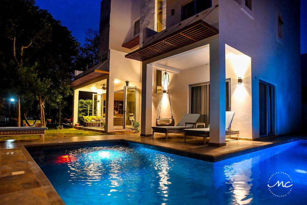 a swimming pool in front of a house at night at Puerto Morelos, Villa Mimi, Private Pool in Puerto Morelos