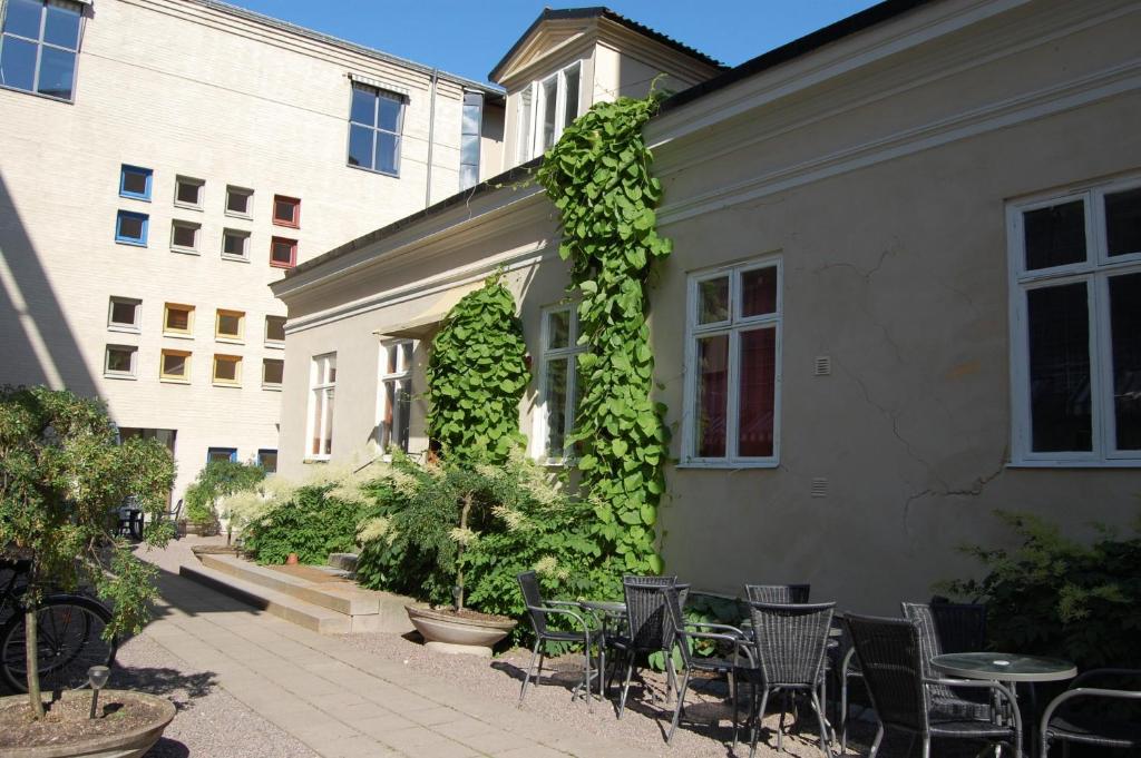 un patio con mesas y sillas junto a un edificio en Vandrarhem Uppsala Kungsängstorg, en Uppsala