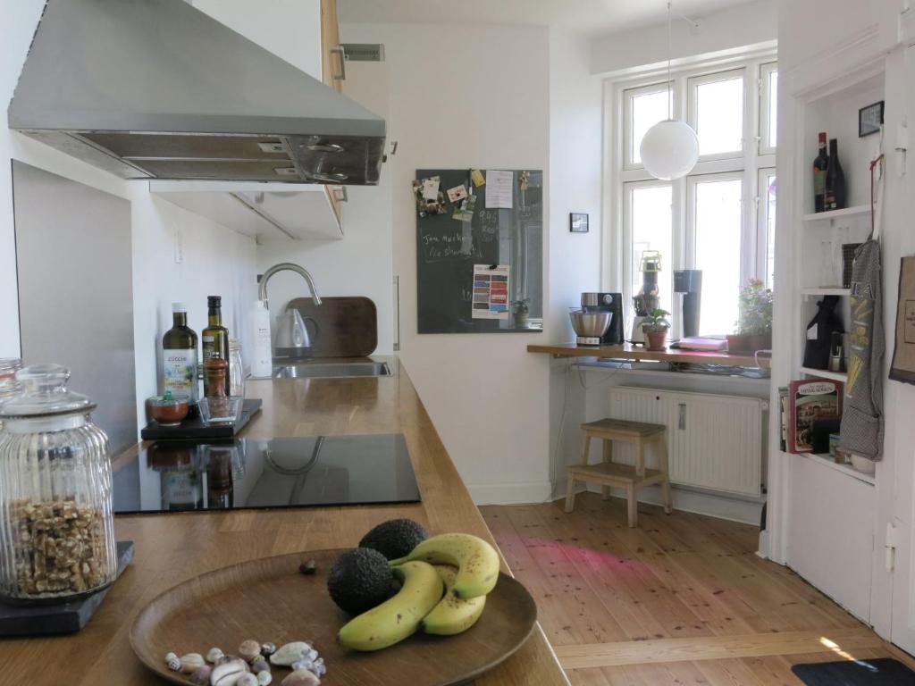 een keuken met een fruitschaal op een tafel bij ApartmentInCopenhagen Apartment 1376 in Kopenhagen