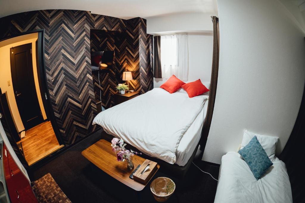 大阪市にあるロイヤルハイツ桜川コンドミニアムのベッドとテーブル付きの小さな部屋