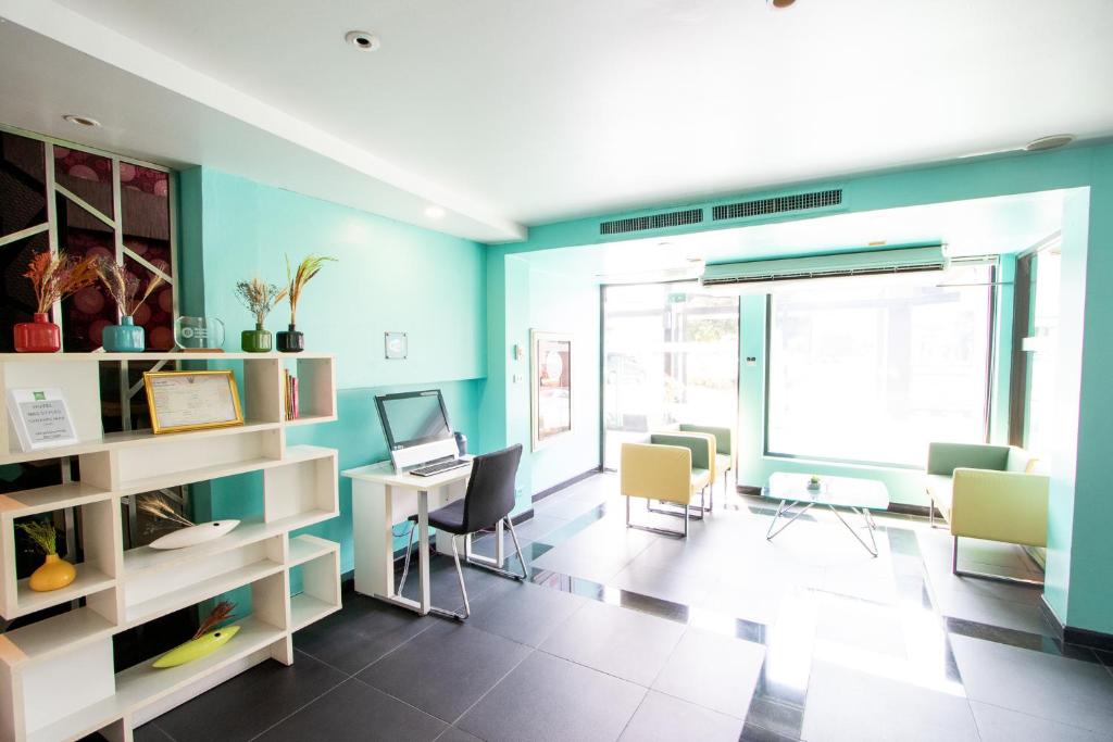 A bright shared work lounge combines individual desks with casual seating by large windows.