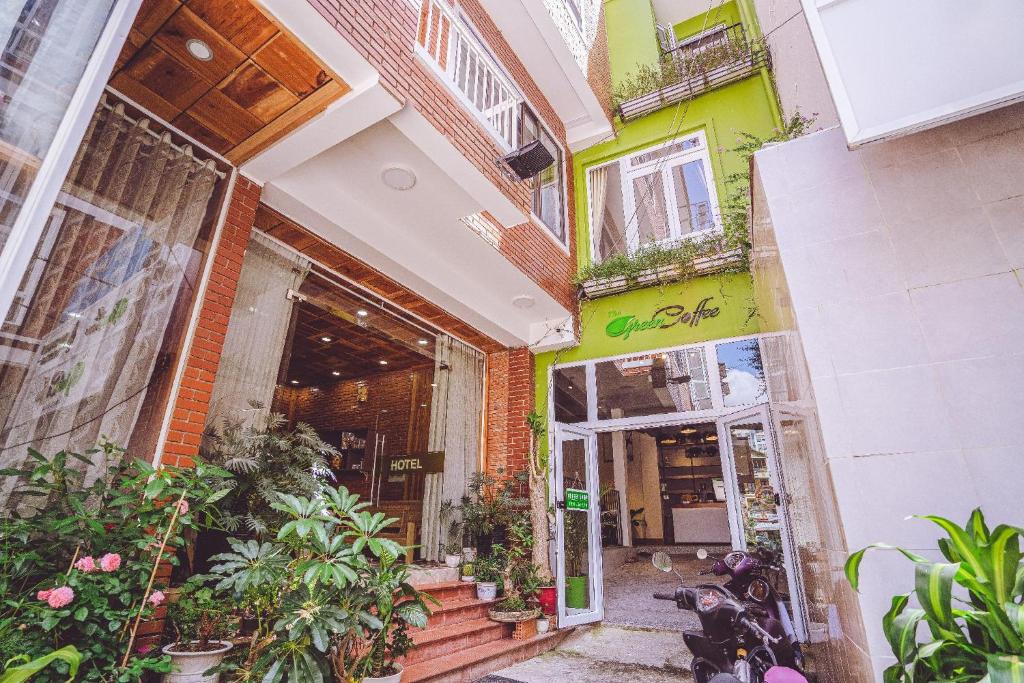 un bâtiment avec des fleurs et des plantes devant lui dans l'établissement Jessy's Green House Da Lat, à Đà Lạt