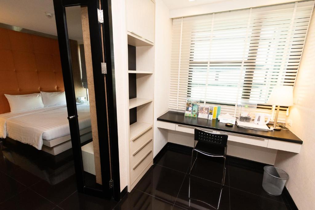 A built-in desk and window seat occupy the bright work area beside the bedroom.