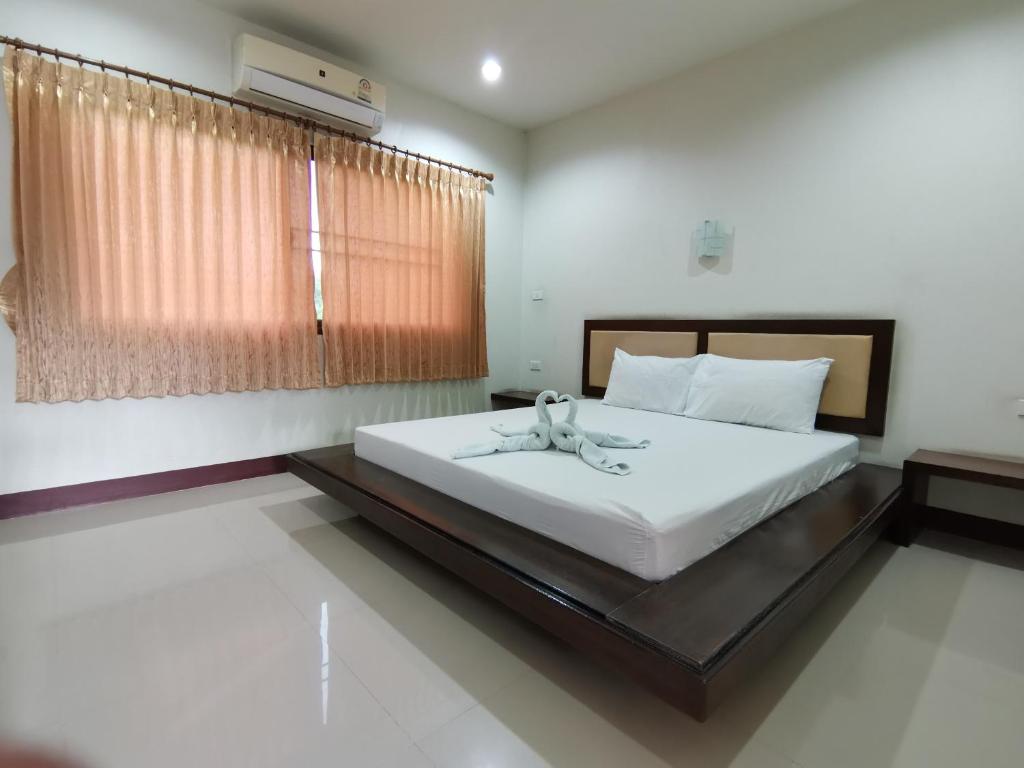 a bedroom with a large white bed and a window at Nestvilla Khok-kloi Phang-nga in Ban Nai