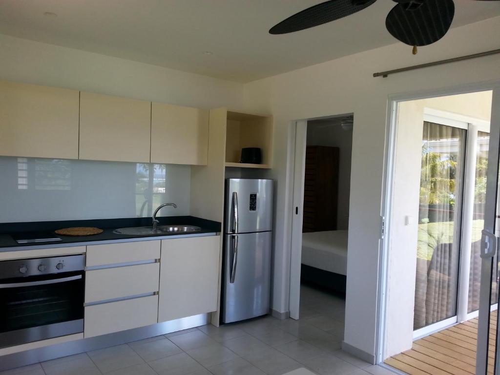 a kitchen with a stainless steel refrigerator and a sink at SNP- PALMS in Papetoai