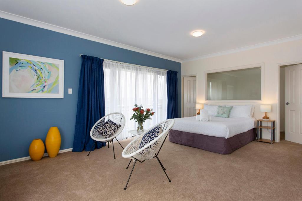 a hotel room with a bed and two chairs at Bella Vista Townhouse with Views in Spearwood