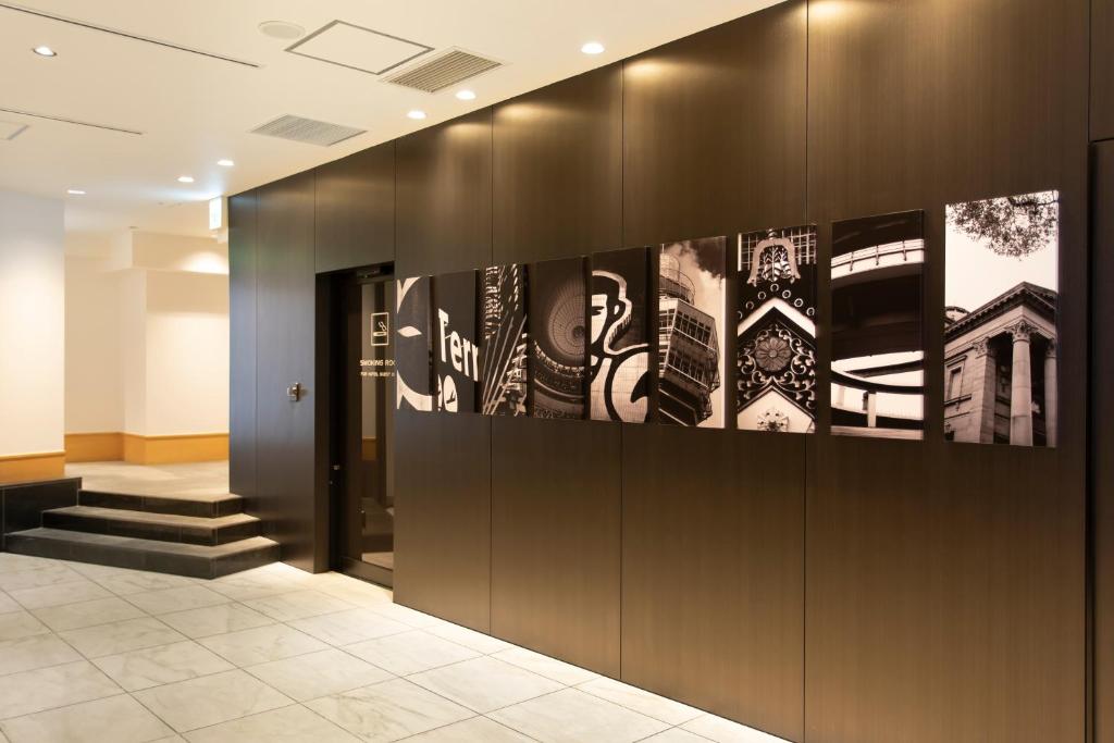 a lobby with black and white posters on the wall at Cross Hotel Osaka in Osaka
