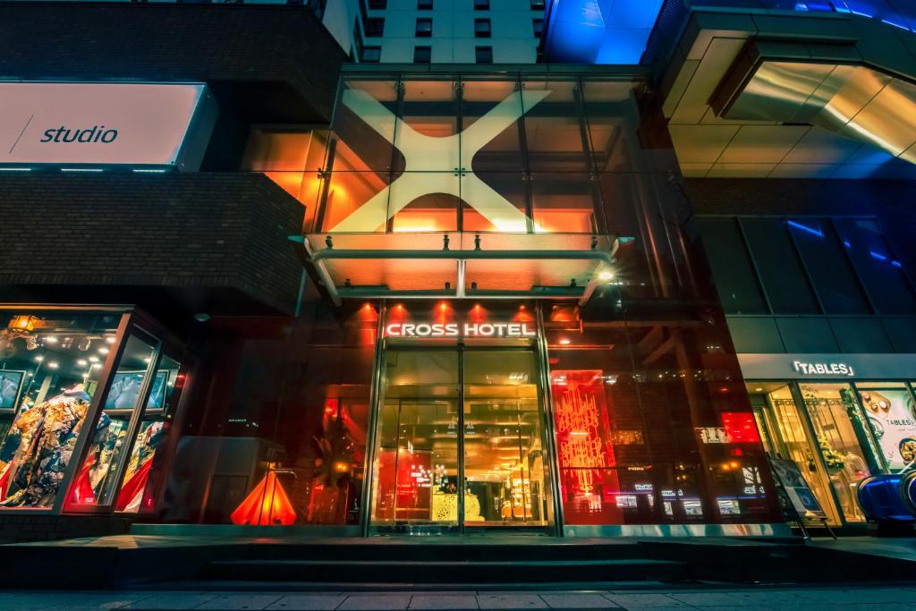 una tienda frente a un edificio por la noche en Cross Hotel Osaka en Osaka